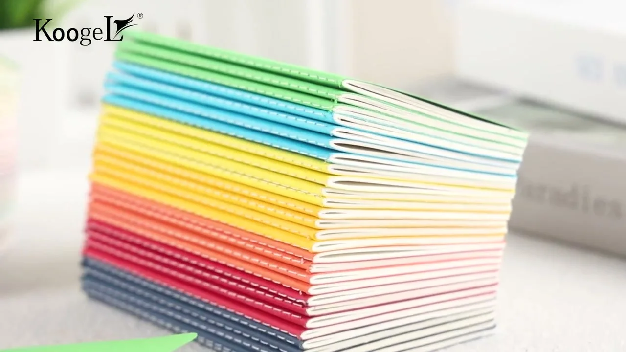 Opening frame of the Koogel film: a rainbow stack of mini notebooks